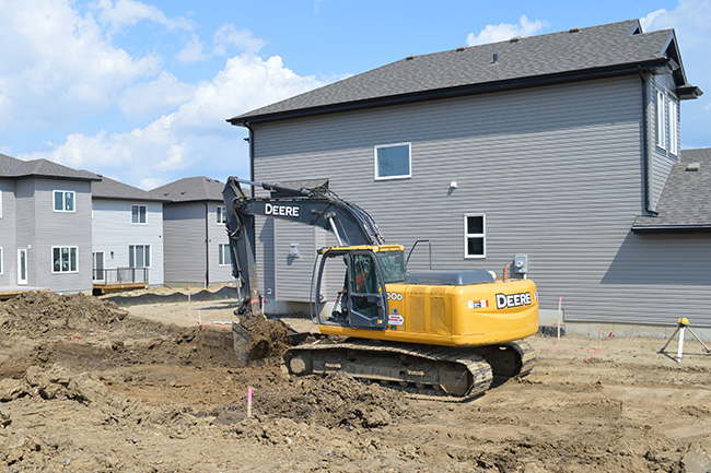 Backhoe excavating a residential basement by Superior Trenching Ltd.